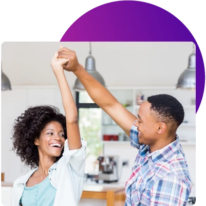 a young couple dancing in their new home thanks to a great low interest rate from their Wellby adjustable-rate mortgage